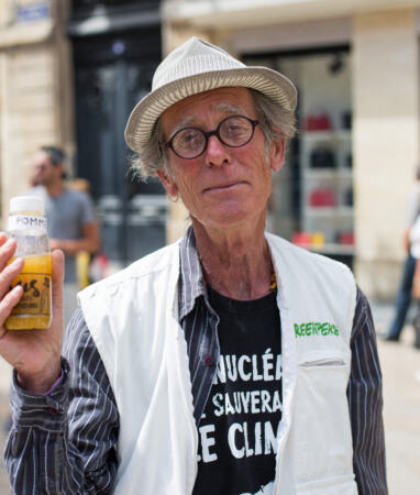 Jacques Delor montre une bouteille de jus de pesticides (campagne Greenpeace pour l'Agriculture écologique)