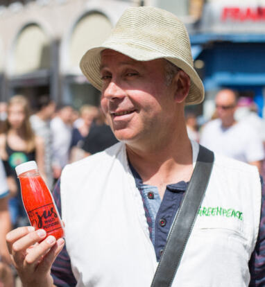 Michaël montre une bouteille de jus de pesticides (campagne Greenpeace pour l'Agriculture écologique)