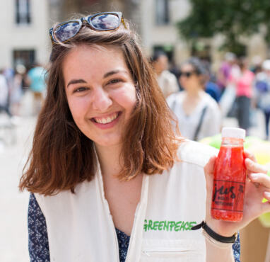 Paloma montre une bouteille de jus de pesticides (campagne Greenpeace pour l'Agriculture écologique)