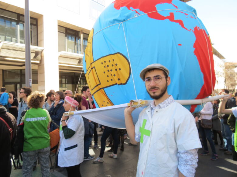 Militant Greenpeace qui porte la planète Terre malade