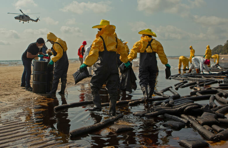 Nettoyeurs sur une plage thaïlandaise mazoutée 