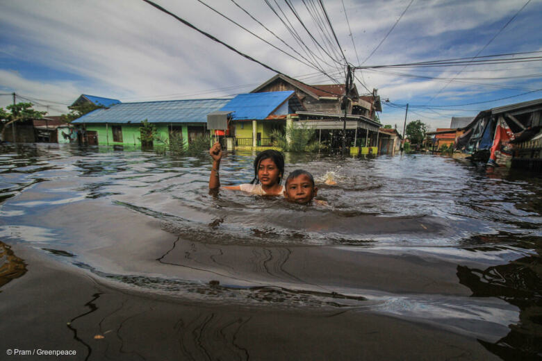 Des enfants nagent dans une rue inondée, en Indonésie, lors des inondations de novembre 2021 © Pram / Greenpeace