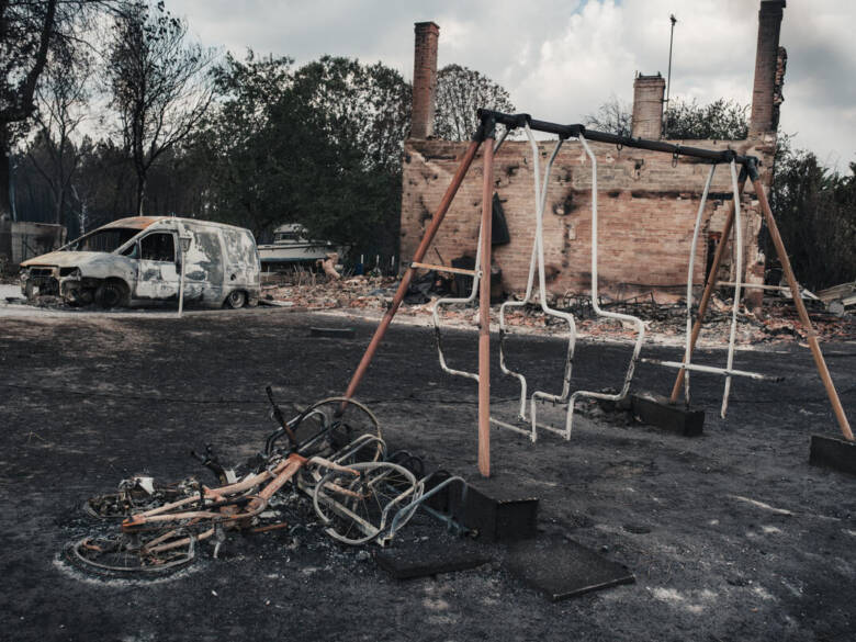 Des jeux pour enfants brulés, un vélo carbonisé, une camionnette endommagée et les restes d'une maison se trouvent sur un sol noirci après un incendie à Lège-Cap-Ferret en Gironde en France.